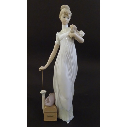 114 - A Lladro figure modelled as a lady with luggage and a small dog, Travelling Companions, model no. 07... 