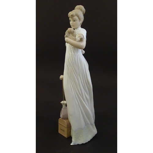 114 - A Lladro figure modelled as a lady with luggage and a small dog, Travelling Companions, model no. 07... 