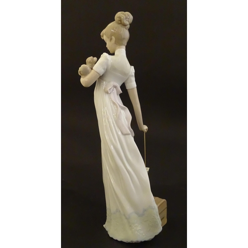 114 - A Lladro figure modelled as a lady with luggage and a small dog, Travelling Companions, model no. 07... 