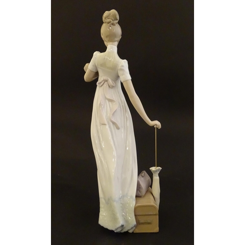 114 - A Lladro figure modelled as a lady with luggage and a small dog, Travelling Companions, model no. 07... 