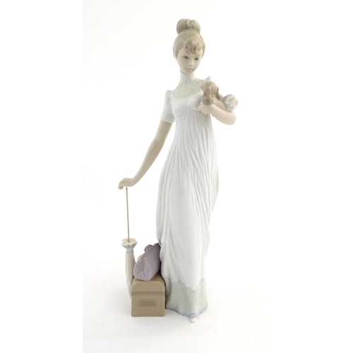 114 - A Lladro figure modelled as a lady with luggage and a small dog, Travelling Companions, model no. 07... 