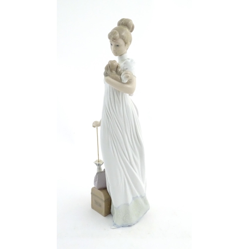 114 - A Lladro figure modelled as a lady with luggage and a small dog, Travelling Companions, model no. 07... 