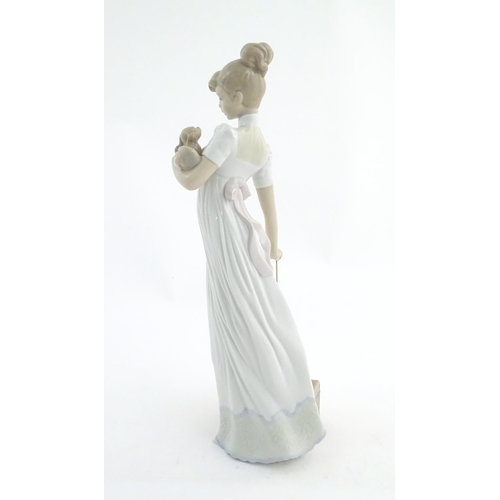 114 - A Lladro figure modelled as a lady with luggage and a small dog, Travelling Companions, model no. 07... 