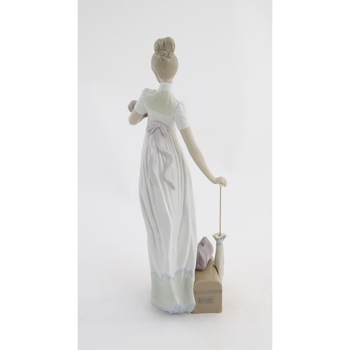 114 - A Lladro figure modelled as a lady with luggage and a small dog, Travelling Companions, model no. 07... 