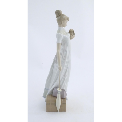 114 - A Lladro figure modelled as a lady with luggage and a small dog, Travelling Companions, model no. 07... 