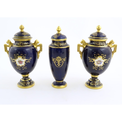 124 - Two Coalport vase and covers with twin handles decorated with hand painted exotic bird vignettes and... 