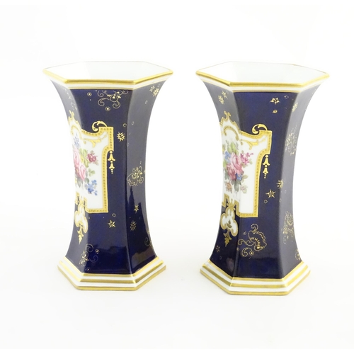 125 - A pair Royal Crown Derby vases of hexagonal flared form with hand painted floral vignettes signed G.... 