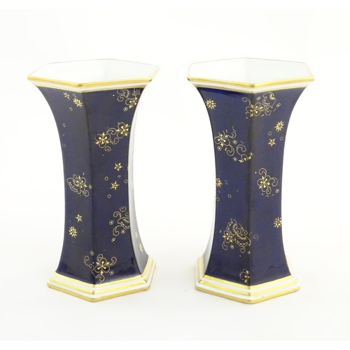 125 - A pair Royal Crown Derby vases of hexagonal flared form with hand painted floral vignettes signed G.... 