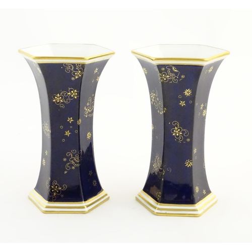 125 - A pair Royal Crown Derby vases of hexagonal flared form with hand painted floral vignettes signed G.... 