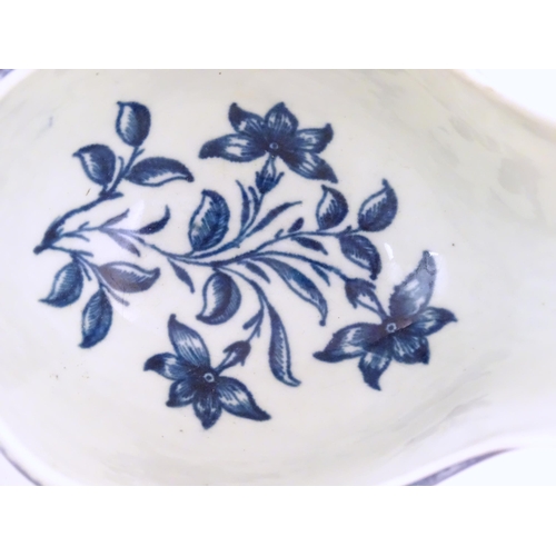 67 - An 18thC blue and white Worcester sauce boat with double scroll handle and thumb rest, decorated in ... 