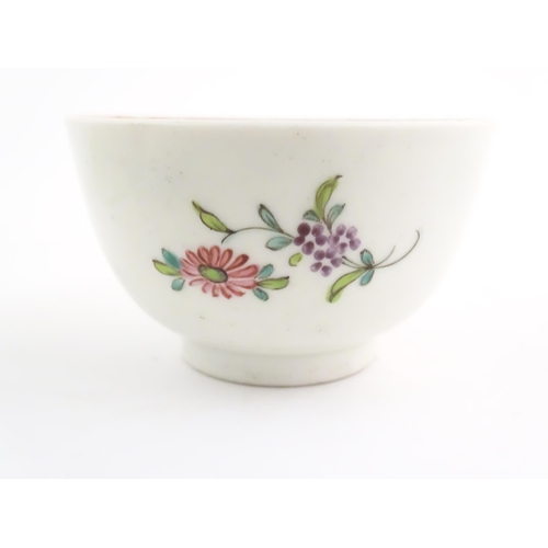 73 - An English late 18th / early 19thC tea bowl and saucer with hand painted floral decoration. In the m... 