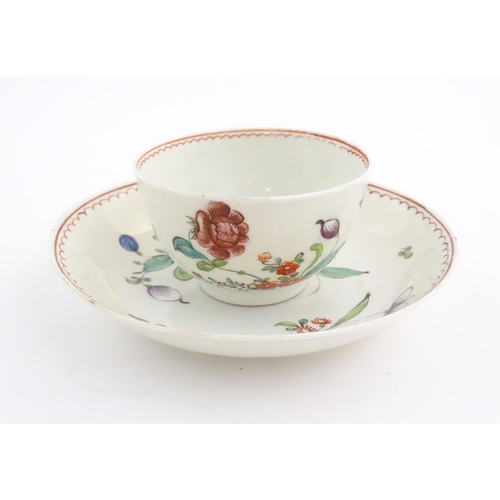 73 - An English late 18th / early 19thC tea bowl and saucer with hand painted floral decoration. In the m... 