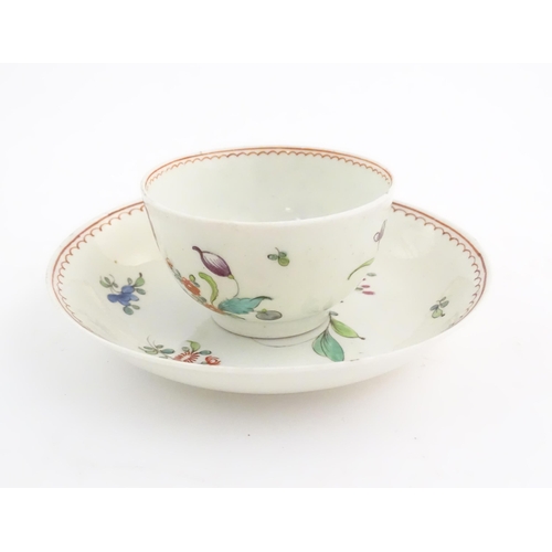 73 - An English late 18th / early 19thC tea bowl and saucer with hand painted floral decoration. In the m... 