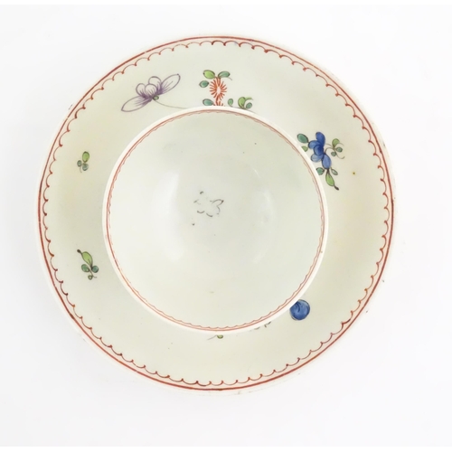 73 - An English late 18th / early 19thC tea bowl and saucer with hand painted floral decoration. In the m... 