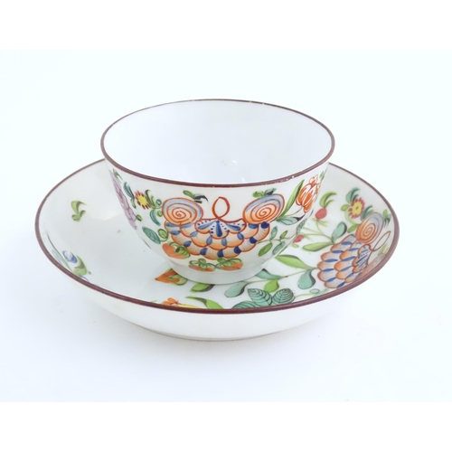 75 - A 19thC English porcelain tea bowl and saucer with hand painted floral and foliate decoration. The s... 