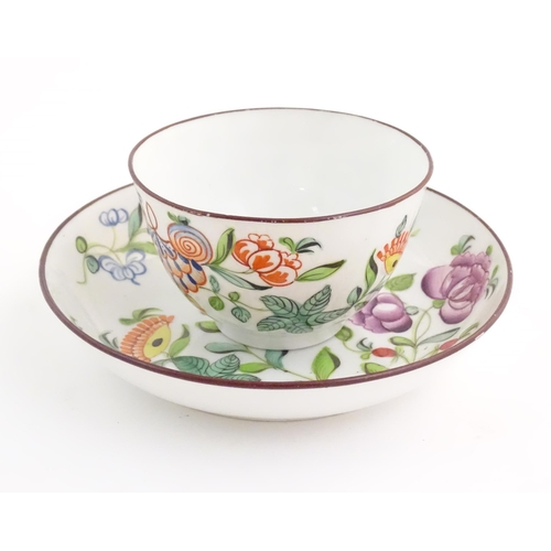 75 - A 19thC English porcelain tea bowl and saucer with hand painted floral and foliate decoration. The s... 