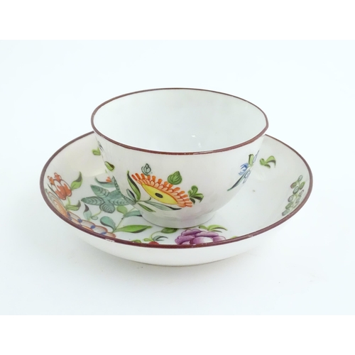 75 - A 19thC English porcelain tea bowl and saucer with hand painted floral and foliate decoration. The s... 