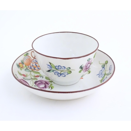 75 - A 19thC English porcelain tea bowl and saucer with hand painted floral and foliate decoration. The s... 