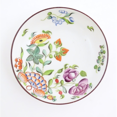 75 - A 19thC English porcelain tea bowl and saucer with hand painted floral and foliate decoration. The s... 