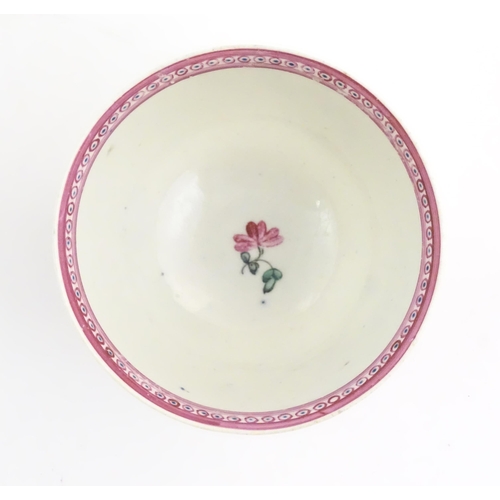 76 - An English late 18th / early 19thC tea bowl and saucer with hand painted floral decoration and a puc... 