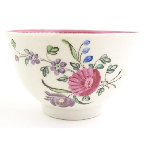 76 - An English late 18th / early 19thC tea bowl and saucer with hand painted floral decoration and a puc... 