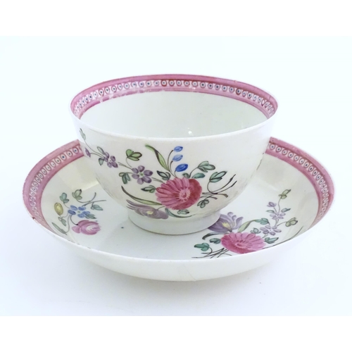 76 - An English late 18th / early 19thC tea bowl and saucer with hand painted floral decoration and a puc... 