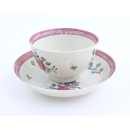 76 - An English late 18th / early 19thC tea bowl and saucer with hand painted floral decoration and a puc... 