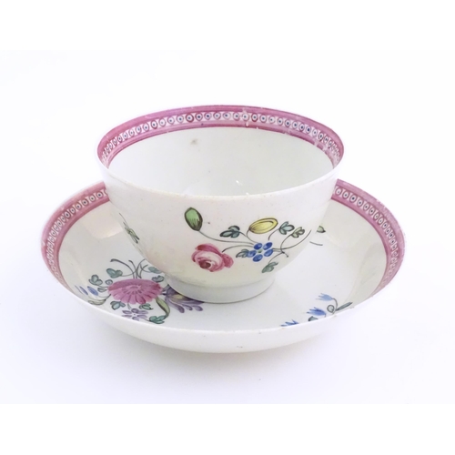 76 - An English late 18th / early 19thC tea bowl and saucer with hand painted floral decoration and a puc... 