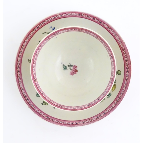 76 - An English late 18th / early 19thC tea bowl and saucer with hand painted floral decoration and a puc... 