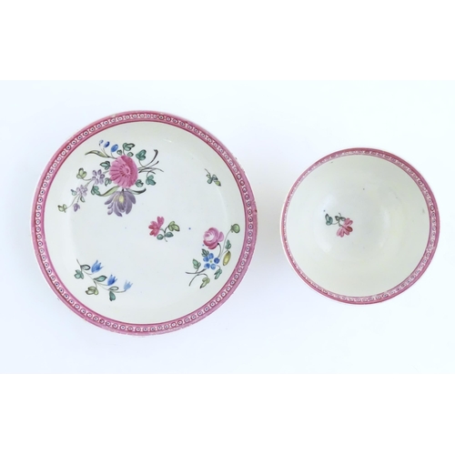 76 - An English late 18th / early 19thC tea bowl and saucer with hand painted floral decoration and a puc... 