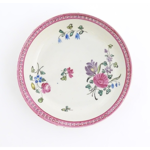 76 - An English late 18th / early 19thC tea bowl and saucer with hand painted floral decoration and a puc... 