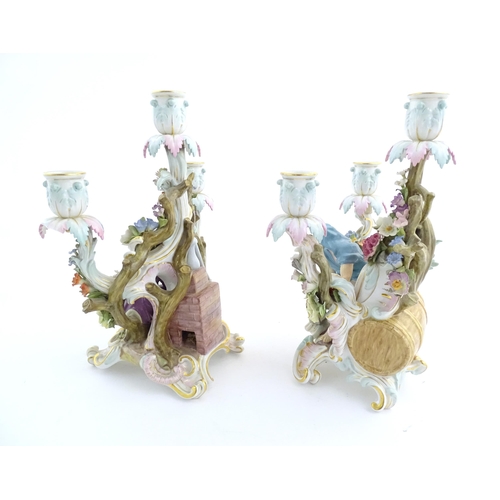 94 - A pair of late 19thC Meissen three branch figural and floral candelabras, one depicting the Greek ph... 