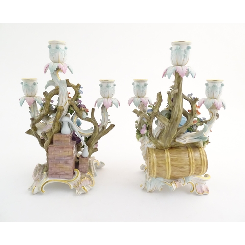 94 - A pair of late 19thC Meissen three branch figural and floral candelabras, one depicting the Greek ph... 