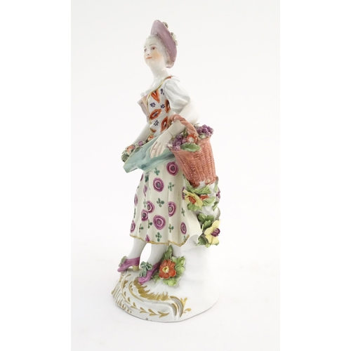 98 - A Derby style figure modelled as a fruit seller with a fruit in her apron and a basket of flowers. A... 