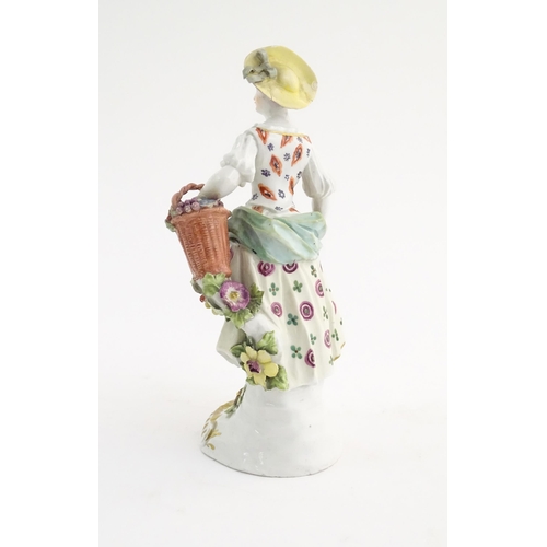 98 - A Derby style figure modelled as a fruit seller with a fruit in her apron and a basket of flowers. A... 