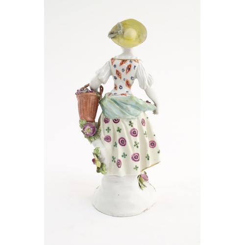 98 - A Derby style figure modelled as a fruit seller with a fruit in her apron and a basket of flowers. A... 