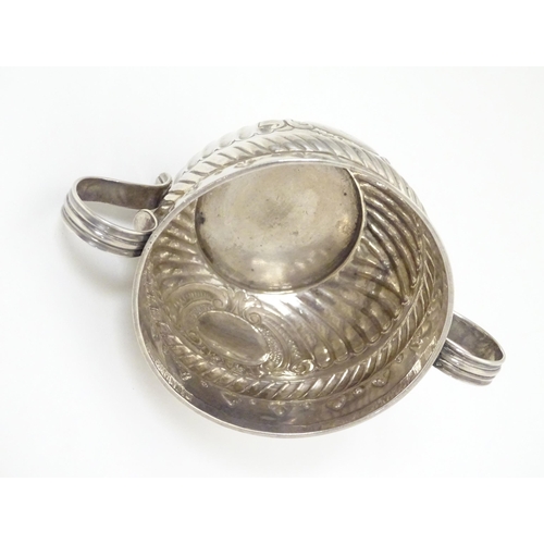 312 - WITHDRAWN FROM AUCTION - Apologies for any inconvenience. A Geo III silver porringer with fluted and... 