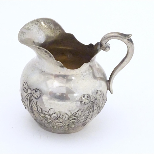 322 - A small Continental .800 silver cream jug with ribbon and swag decoration. Marked under possibly Han... 