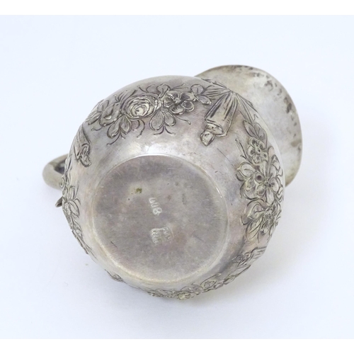 322 - A small Continental .800 silver cream jug with ribbon and swag decoration. Marked under possibly Han... 