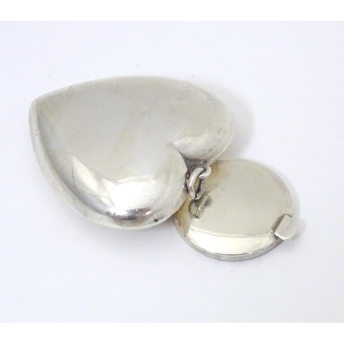 325 - A small silver powder compact of heart shape. Hallmarked Birmingham 1917 maker Henry Williamson Ltd ... 