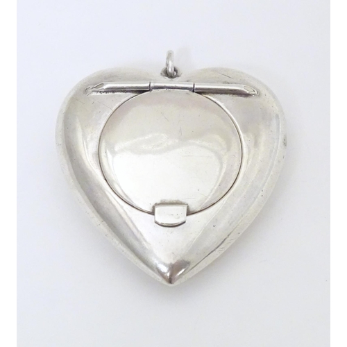 325 - A small silver powder compact of heart shape. Hallmarked Birmingham 1917 maker Henry Williamson Ltd ... 