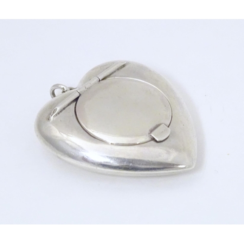 325 - A small silver powder compact of heart shape. Hallmarked Birmingham 1917 maker Henry Williamson Ltd ... 