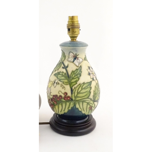 155 - A Moorcroft table lamp base decorated in the Strawberry Plant and Butterfly pattern, on a turned woo... 