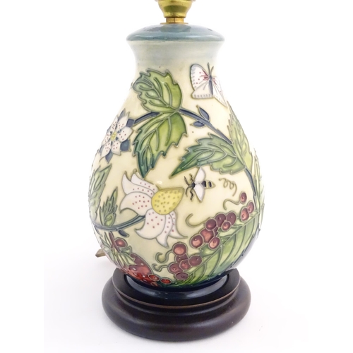 155 - A Moorcroft table lamp base decorated in the Strawberry Plant and Butterfly pattern, on a turned woo... 