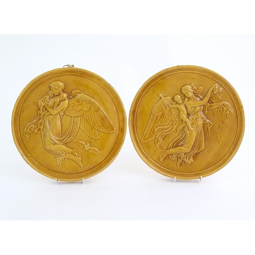 161 - Two Dunmore pottery roundel / plaques depicting a female angel carrying children. One stamped Peter ... 