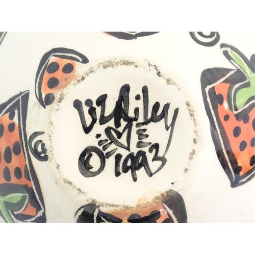 166 - A studio pottery jug and bowl decorated with hand painted strawberry detail by Liz Riley. Marked und... 