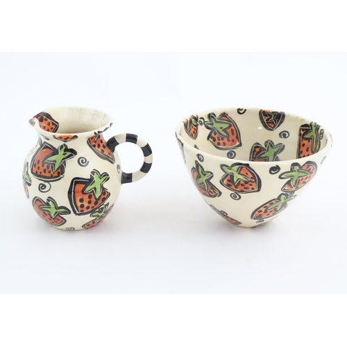 166 - A studio pottery jug and bowl decorated with hand painted strawberry detail by Liz Riley. Marked und... 