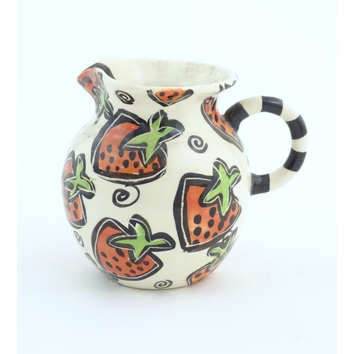 166 - A studio pottery jug and bowl decorated with hand painted strawberry detail by Liz Riley. Marked und... 