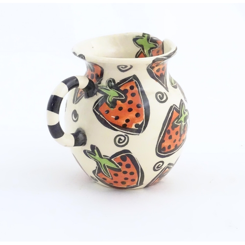 166 - A studio pottery jug and bowl decorated with hand painted strawberry detail by Liz Riley. Marked und... 