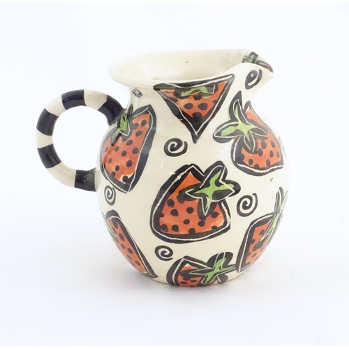 166 - A studio pottery jug and bowl decorated with hand painted strawberry detail by Liz Riley. Marked und... 